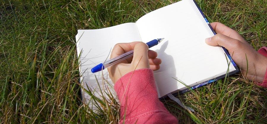 Writing in a notebook in a field