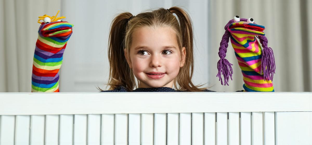 Girl playing with homemade puppets