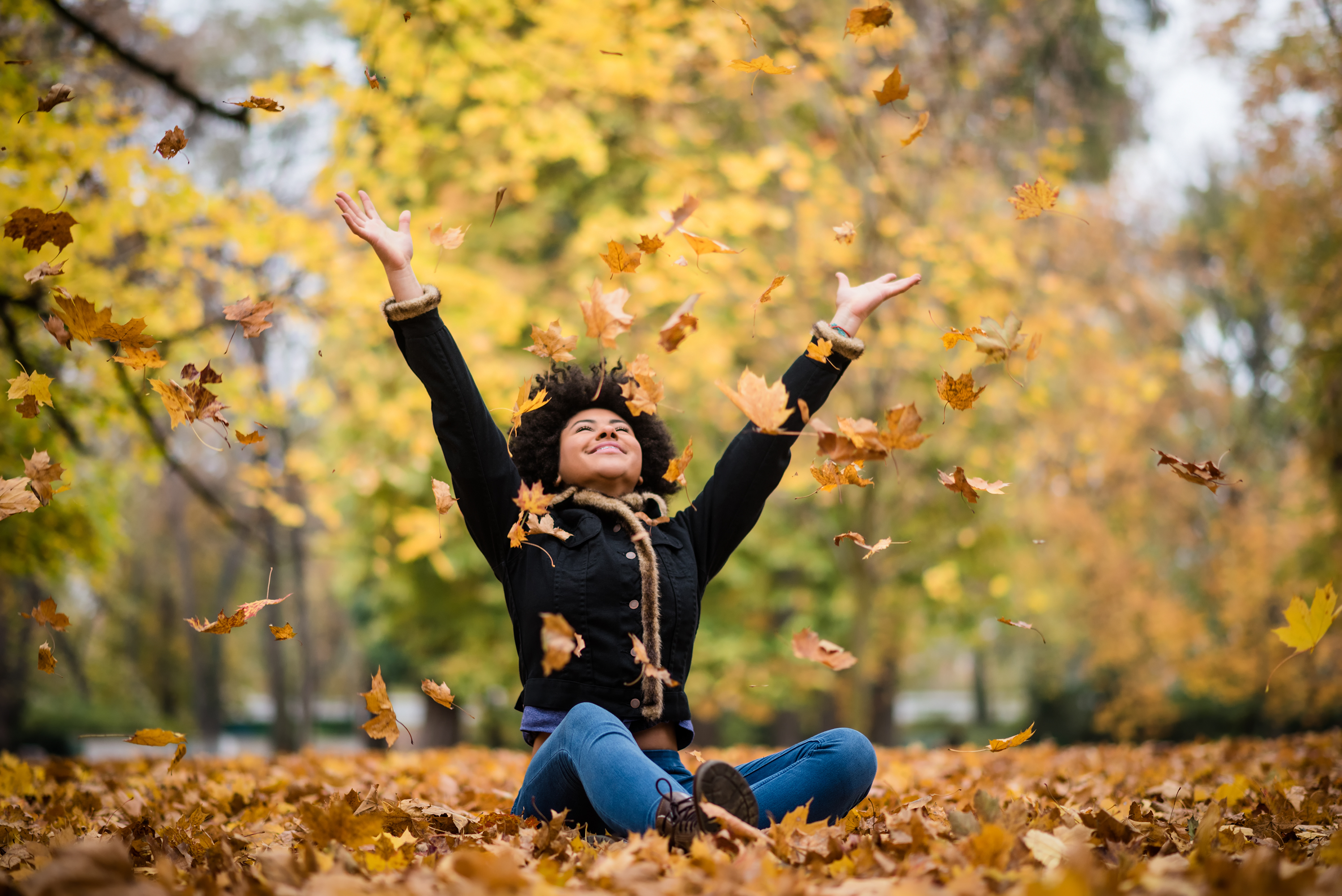 Woman surrounded by leaves on campus