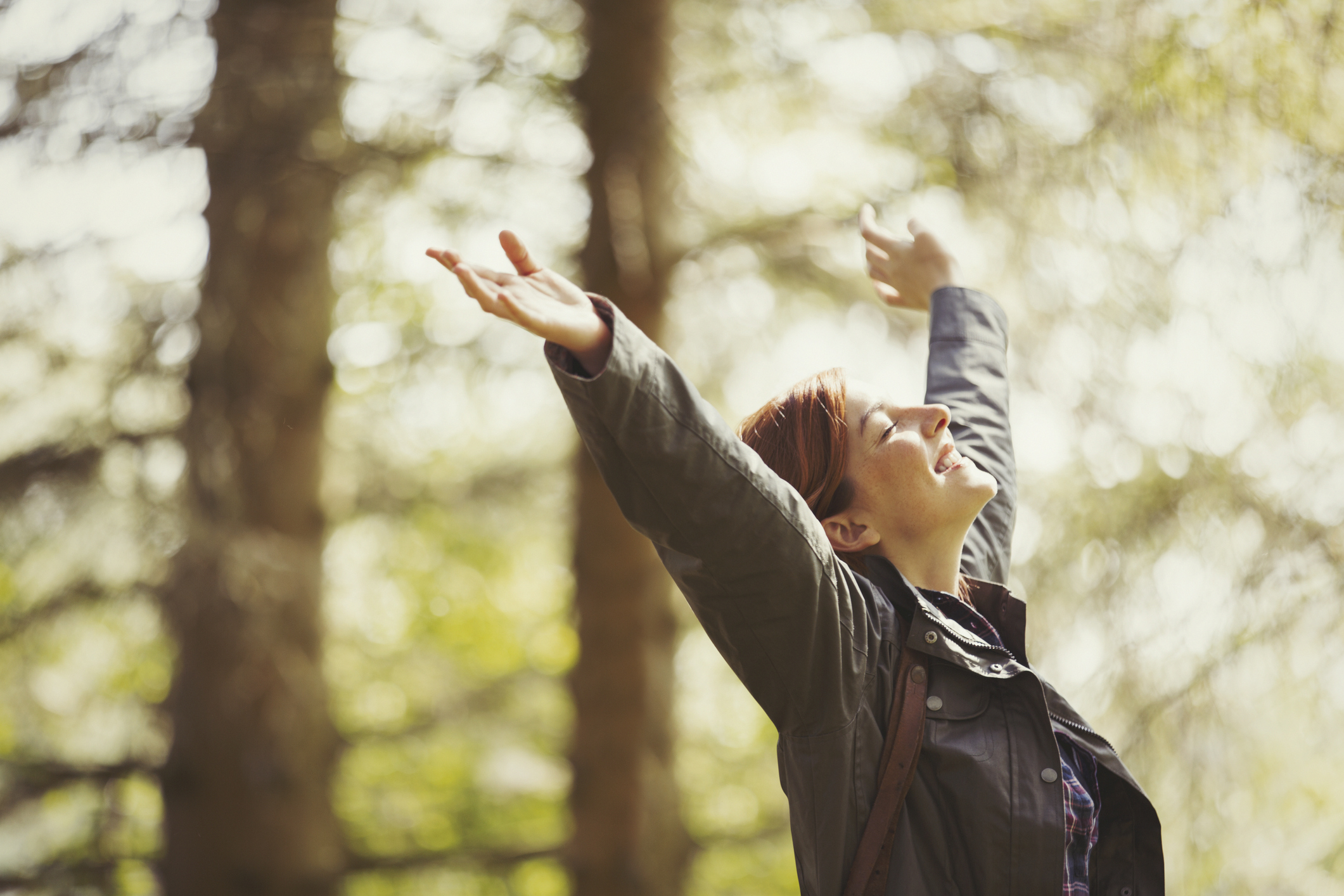 Woman with arms raised enjoying the sun on her face