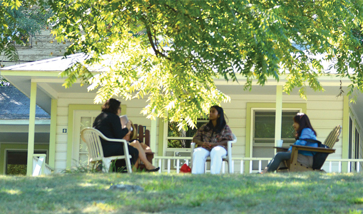Circle of friends sitting outside on a leafy spring day