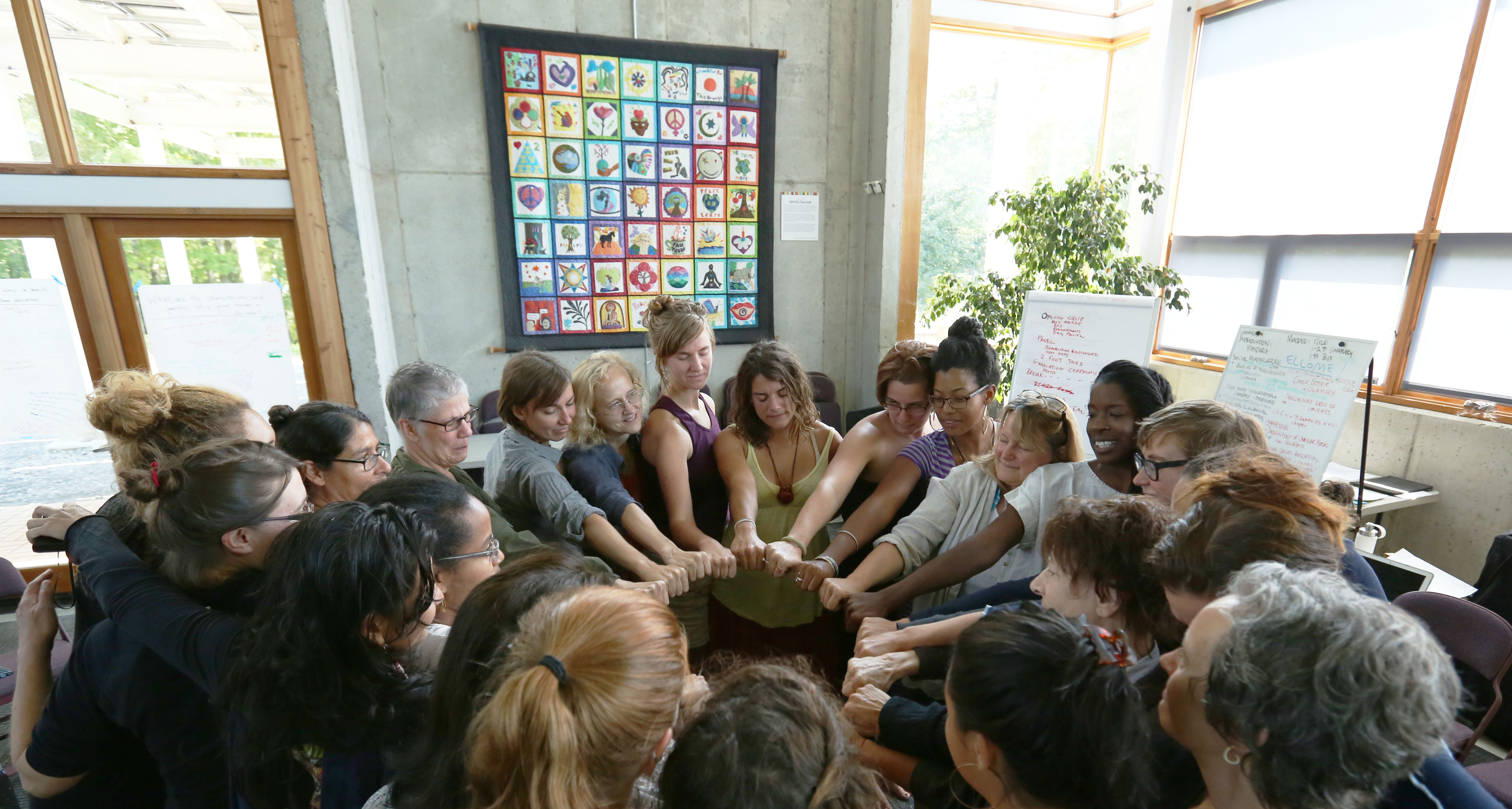 women with hands together, forming a circle
