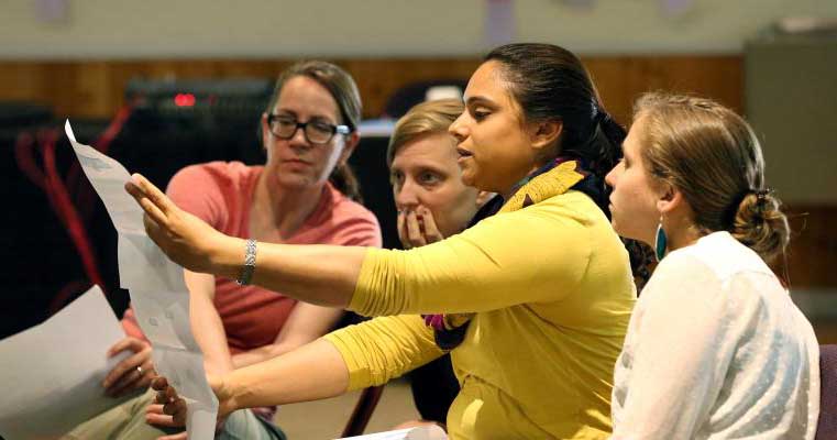 4 women intensely studying a plan 