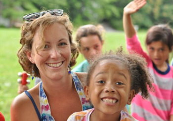 Mom &amp; daughter smiling with more kids in background