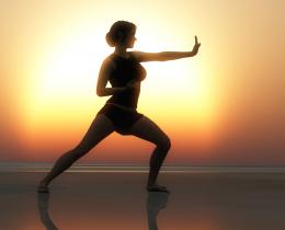 Woman practicing Tai Chi at sunrise on the beach, illustrating the flow of subtle energy like prana and qi for enhanced health and well-being.
