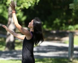 Woman practicing somatic movement outdoors in a peaceful, tree-lined setting, embodying mindfulness, body awareness, and holistic wellness through somatic healing practices.