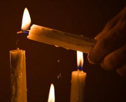 Lighting candles in darkness symbolizing feminine spirituality and sacred texts in the Mary Magdalene Gospel.