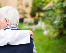 Elderly person and their caregiver in a park