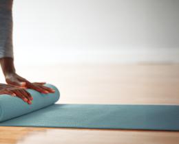Black woman rolling up her yoga mat