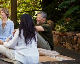 Group of adults gathering outdoors for mindful conversation and connection during an analog wellness retreat focused on presence, community, and digital well-being.