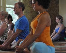 Group of people in a yoga class in Butterfly pose