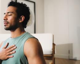 Man practicing breathwork with hand on chest to calm the nervous system.