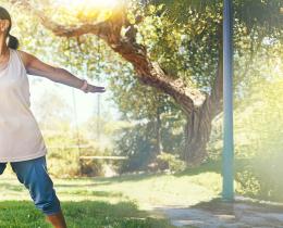 Seniors practicing tai chi balance exercises in a park for fall prevention and healthy aging.