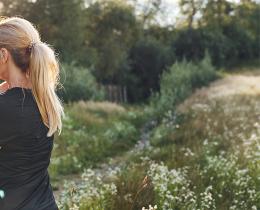 Woman doing a mindful movement exercise outdoors in a field