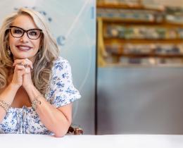 Spiritual medium Susan Grau smiling, seated with hands clasped.