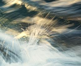 Ocean waves flowing over rocks, illustrating the movement of water, connection, and the embodied practice of belonging in nature.