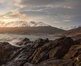 Rocky coastline and open sea at sunset, evoking the epic journey and homecoming of Homer’s The Odyssey.