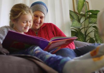 Woman &amp; child reading a book together