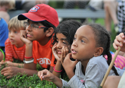 Attentive children lying in grass