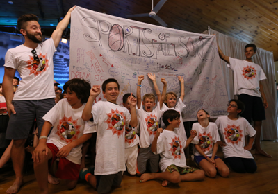 Kids in Sports T-Shirts in front of a banner