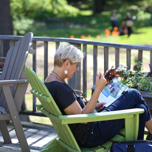 Woman reads Omega's Catalog while sitting on the Café deck