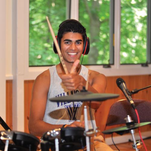 Young man plays a drum kit