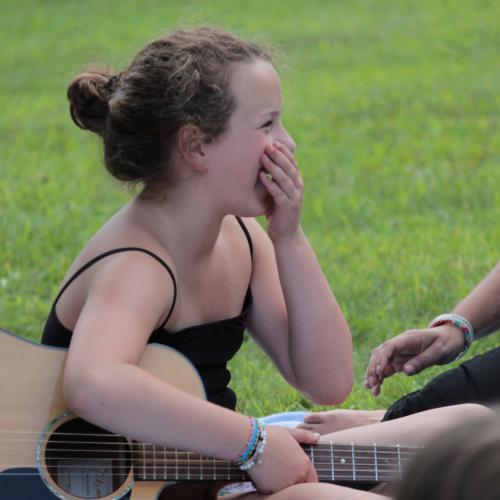 Young woman with guitar, laughing