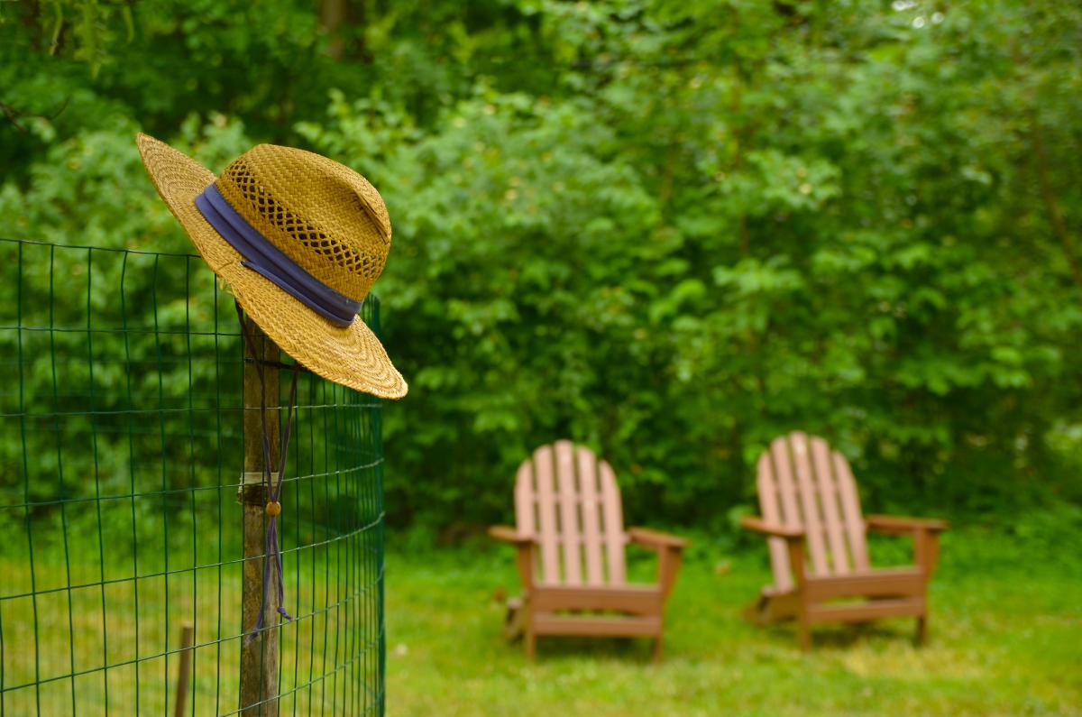 2 Adirondack chairs and a hat on a post