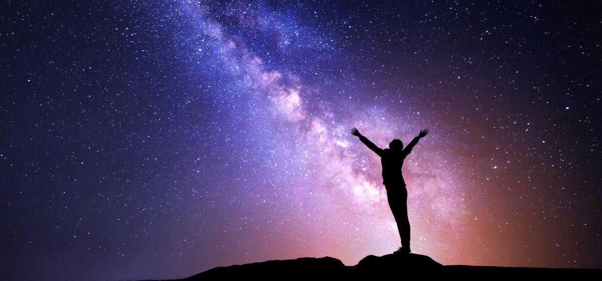 Woman reaching towards the stars in the sky