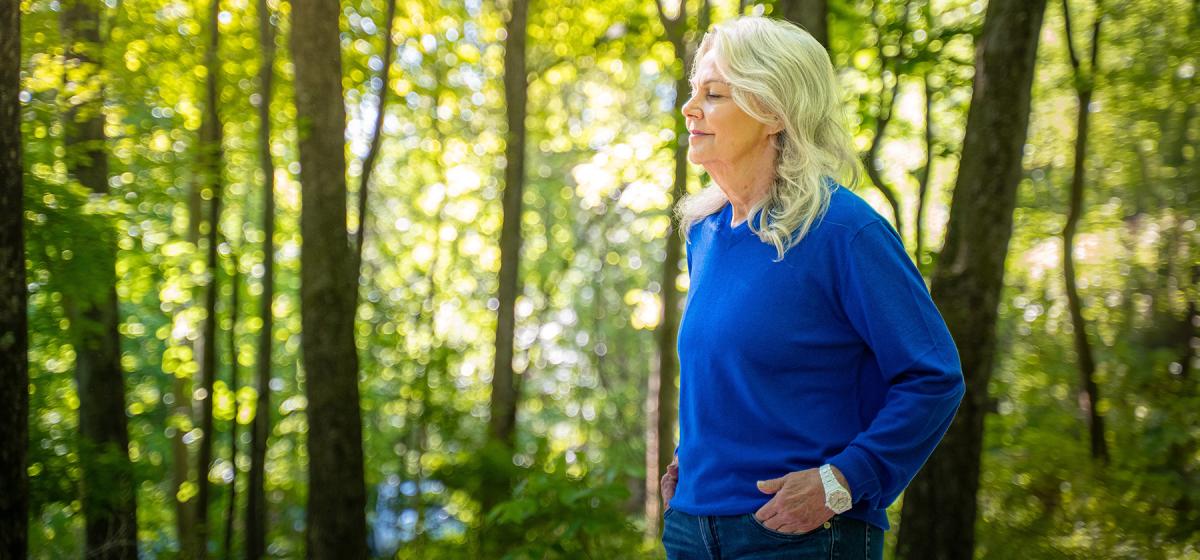 Barb Schmidt standing peacefully in the forest