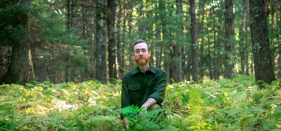 Nick Werber sitting in a field full of ferns