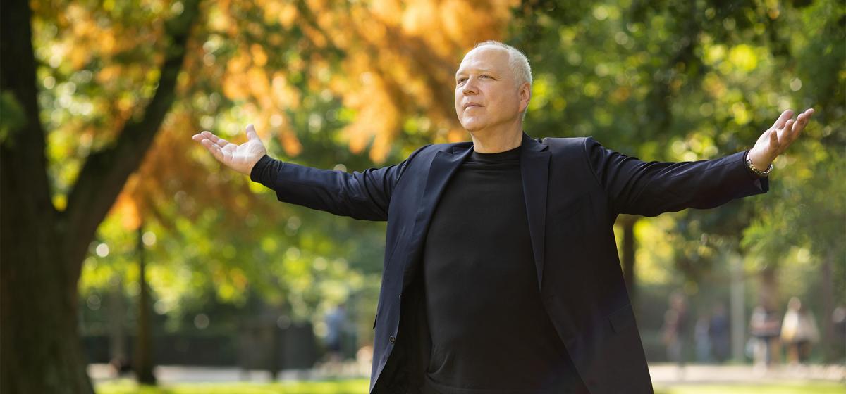 Max Strom with his arms open wide in a breathing exercise