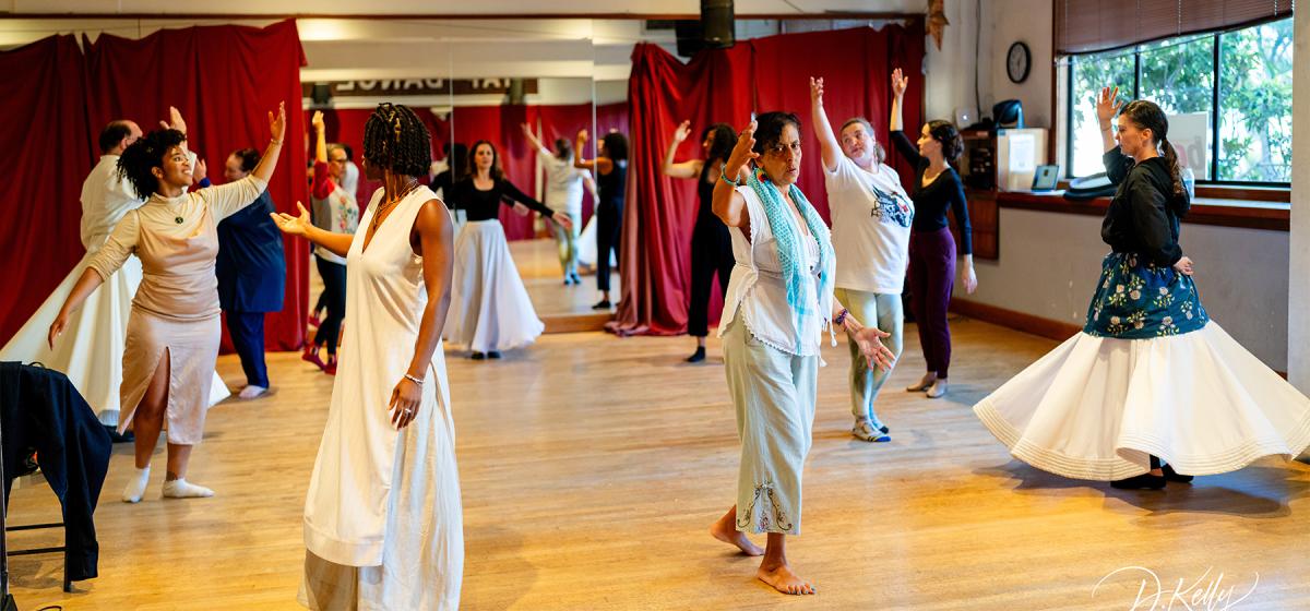 Group of people whirling in a Sufi dance class led by Farima Berenji