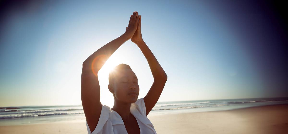 Black woman in breathing exercise on beach