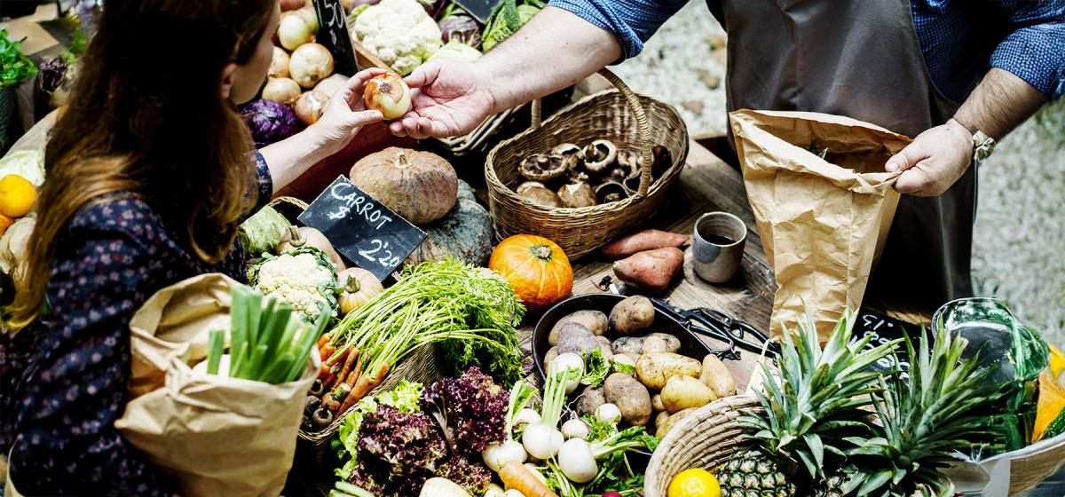 Person buying produce at farmers market