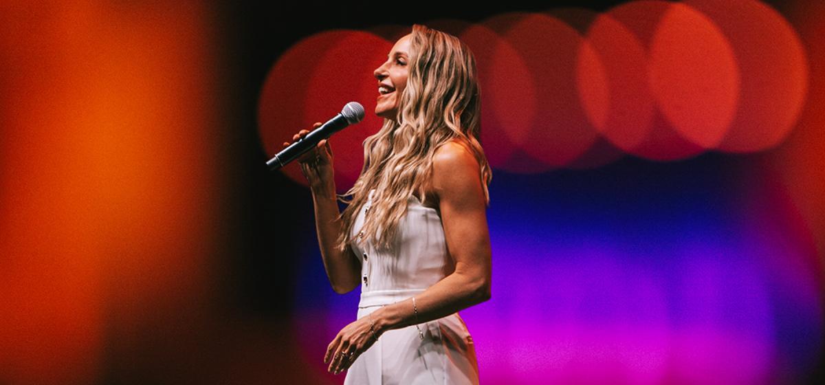 Gabby Bernstein standing on a stage teaching