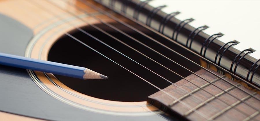 Pencil, notebook, and guitar