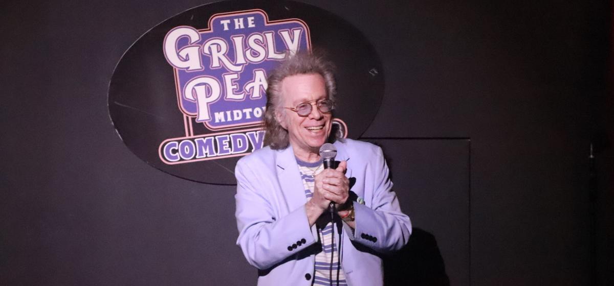 Jeffrey Gurian on stage at a comedy club