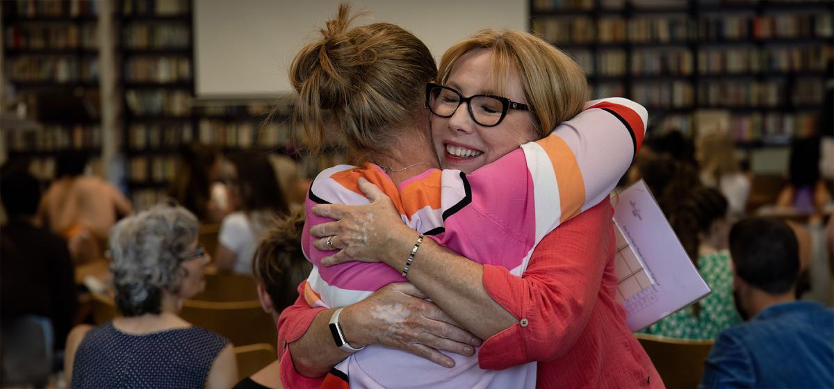 Anna Runkle embracing a participant at a workshop