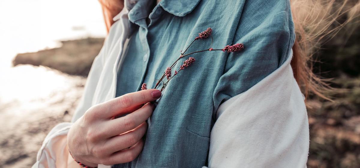 Woman holding a branch of wildflowers against her heart