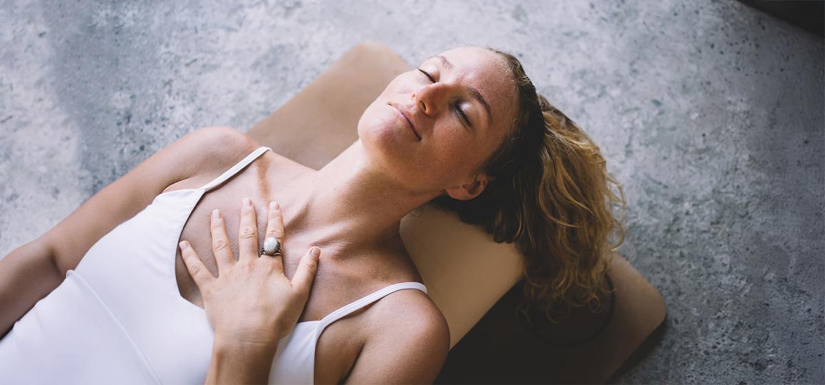 Woman laying on floor in a breathwork exercise