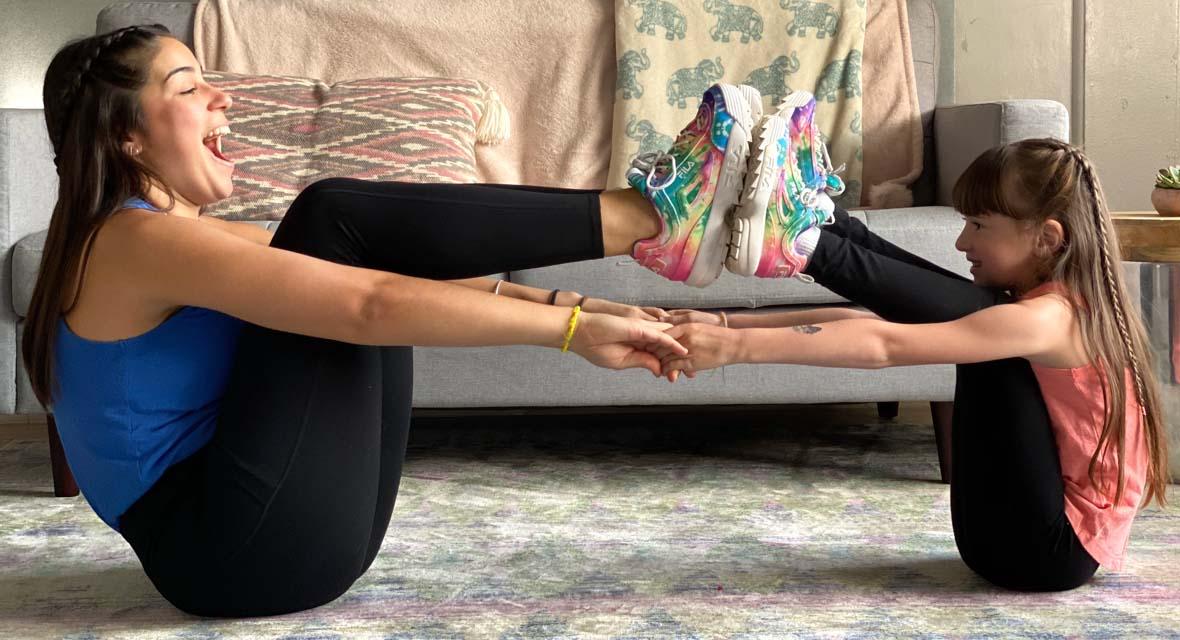 Jenn Cohen Harper doing yoga at home with a young girl.