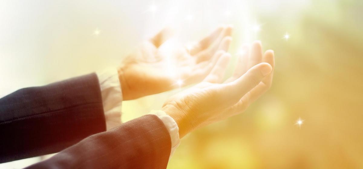 hands reaching out and receiving light
