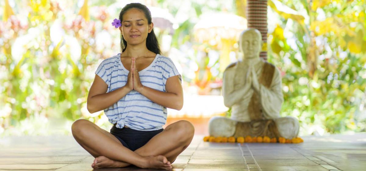 Woman next to statue of Buddha