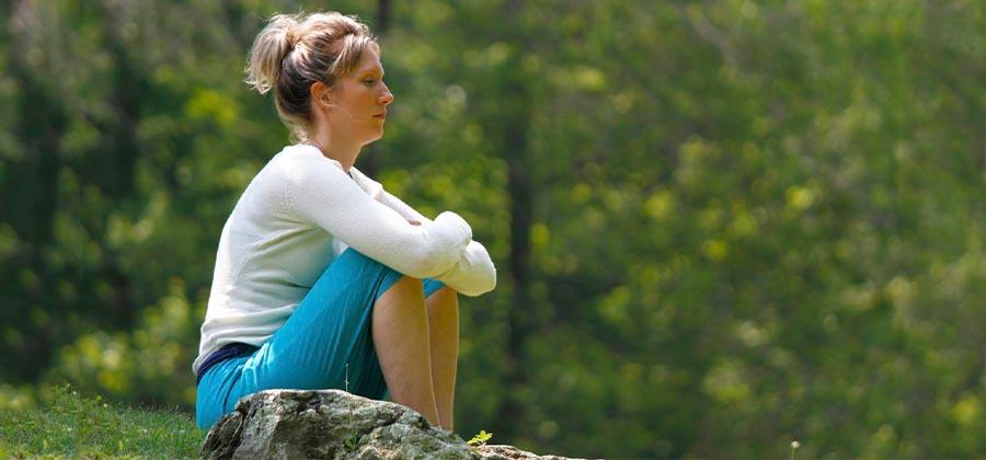 Woman sitting on the grass meditating