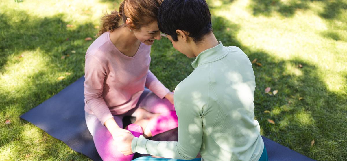 Lesbian couple in meditation practice outside