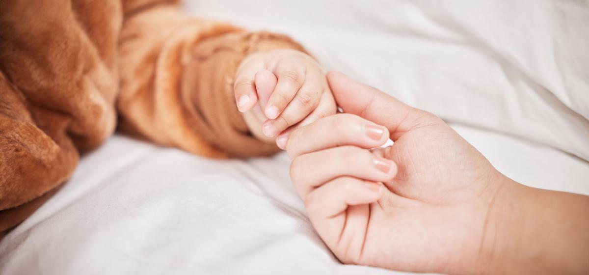 Person holding a baby's hand