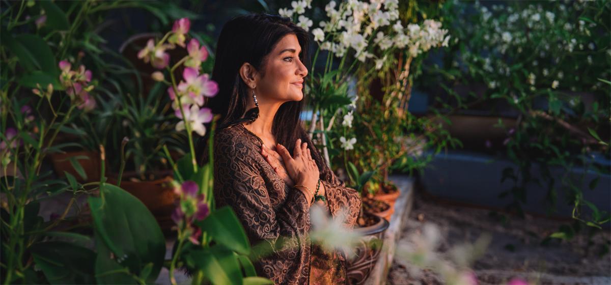 Monika Nataraj meditating in a flower garden