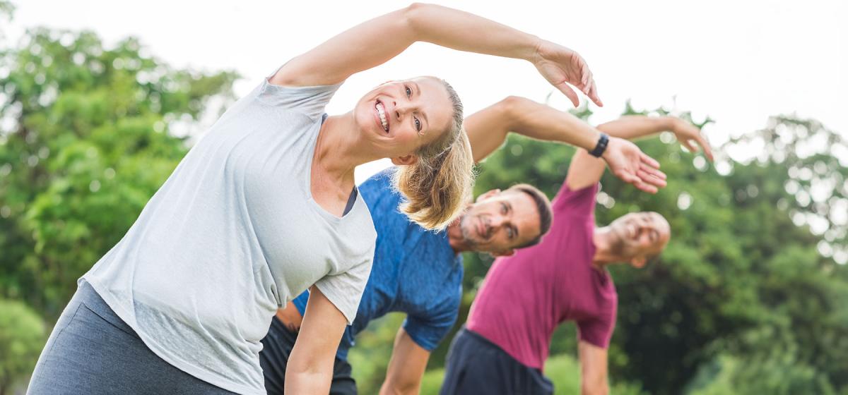 Group of people stretching in a park