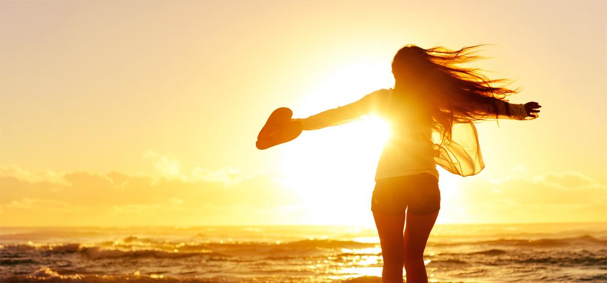 Person dancing joyfully alone at sunset